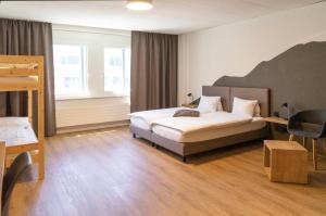 Postel nebo postele na pokoji v ubytování Tailormade Hotel STANS SÜD