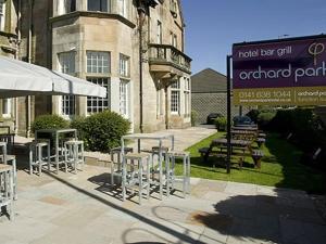 a group of tables and chairs in front of a building at Orchard Park Hotel in Giffnock