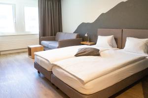 Voodi või voodid majutusasutuse Tailormade Hotel STANS SÜD toas