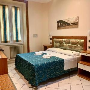 a bedroom with a large bed with a blue blanket at Optimus B&B in Rome