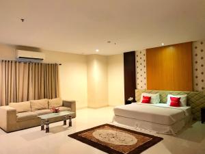 duża sypialnia z łóżkiem i kanapą w obiekcie Ameera Hotel w mieście Pekanbaru