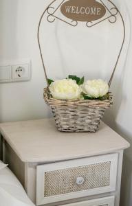 a basket with two white roses on a table at AQUACHAVES - Apart Studios in Chaves