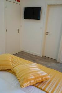1 dormitorio con 1 cama y TV de pantalla plana en la pared en AQUACHAVES - Apart Studios en Chaves
