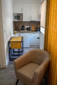 een woonkamer met een bank en een tafel in een keuken bij AQUACHAVES - Apart Studios in Chaves
