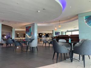 a dining room with tables and chairs in a restaurant at The Pearls Independent Umhlanga - Durban in Durban