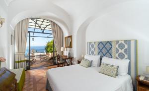 Schlafzimmer mit einem Bett und Meerblick in der Unterkunft Hotel Punta Regina in Positano