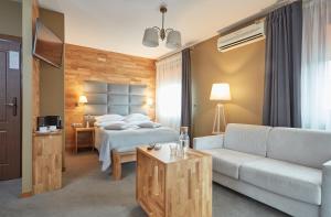 een hotelkamer met een bed en een bank bij Hotel Batory in Krakau