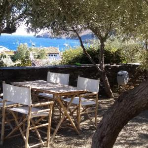 a wooden table and chairs with a view of the ocean at Casa Margot in Cadaqués