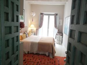 a bedroom with a bed and a large window at Duplex and terrace overlooking Giralda in Seville