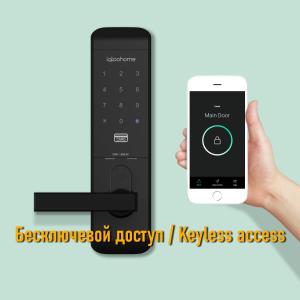 una mano sosteniendo un teléfono inteligente con una cerradura inteligente en la puerta en Aparton, en Minsk