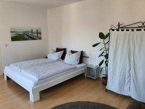 Un dormitorio con una cama con sábanas blancas y una planta en Studio NICO Dominsel, en Brandenburg an der Havel