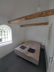 a bedroom with a bed in a room with a window at Lille Knudsgaard in Løkken