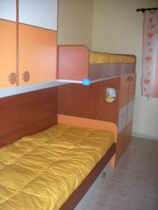 a bedroom with two bunk beds with yellow sheets at Casa Beatrice in Santa Margherita di Pula