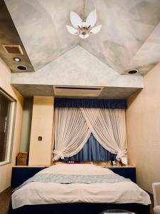 a bedroom with a bed and a ceiling fan at Hotel Sagano (Adult only) in Kyoto
