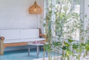 a bench on a porch with plants and a table at Guru Canggu in Canggu