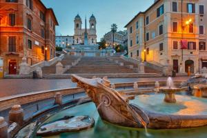 a statue of a boat in a fountain in a city at Bernini apartment in Rome