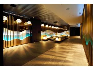 a lobby with couches and tables in a building at Henn na Hotel Nara in Nara