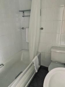 y baño con bañera, aseo y ducha. en My Place Hotel, en Londres