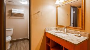 a bathroom with a sink, toilet and mirror at Best Western Plus GranTree Inn in Bozeman