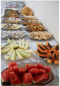 a table filled with different types of fruit on plates at Pousada Vale do Caparaó in Alto Caparao +13 photos