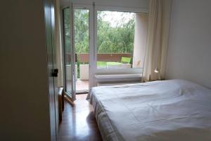 um quarto com uma cama e uma grande janela em Mayenzett 33 em Leukerbad