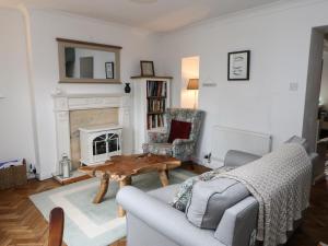 a living room with a couch and a table and a fireplace at Clementine Cottage in Darlington
