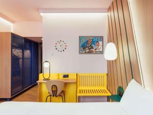 a bedroom with a yellow desk and a yellow chair at Ibis Styles Madrid City Las Ventas in Madrid