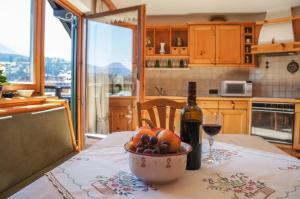 a table with a bowl of fruit and a bottle of wine at Rosas Ferienwohnung in Fieberbrunn