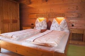 a bedroom with two beds in a log cabin at Rosas Ferienwohnung in Fieberbrunn