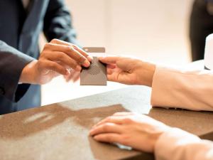 a person holding a piece of paper on a table at Pullman Sharjah in Sharjah