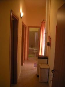 - un couloir dans une salle de bains pourvue d'une baignoire et de toilettes dans l'établissement Casa Beatrice, à Santa Margherita di Pula