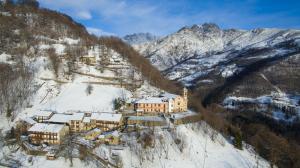 an aerial view of a house on a snowy mountain at BBB Bed&Breakfast Bagneri in Muzzano