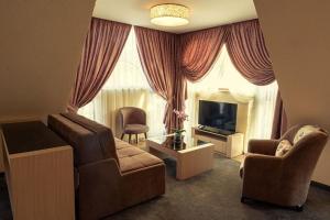 a living room with a couch and a chair and a television at Boutique hotel Provence Бутик хотел Прованс in Petrich