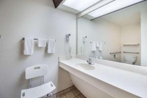 Un baño blanco con lavabo y espejo. en Rodeway Inn Bolivar, en Bolivar 18 fotos más