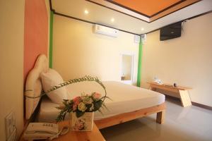 a room with a bed with a phone and flowers on it at Au Hotel in Phra Nakhon Si Ayutthaya