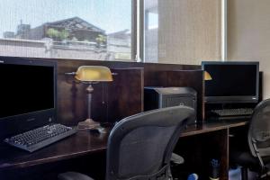 a desk with a computer and a lamp on it at Comfort Suites Visalia Convention Center in Visalia