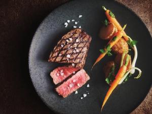 a plate of food with meat and carrots on it at ANA InterContinental Ishigaki Resort by IHG in Ishigaki Island