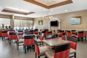 un restaurante con mesas y sillas y TV de pantalla plana en Comfort Inn & Suites Marianna I-10, en Marianna