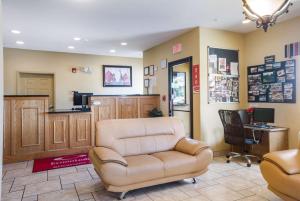 una sala d'attesa con una sedia in pelle e una scrivania di Econo Lodge Inn & Suites a Rockmart