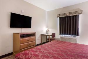 a hotel room with a bed and a flat screen tv at Econo Lodge Inn & Suites Rockmart in Rockmart