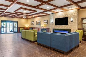 a lobby with couches and a flat screen tv at Comfort Suites Grand Rapids North in Comstock Park