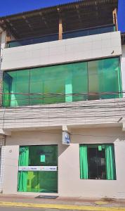 a building with green curtains on the side of it at Pousada Marahub in Maragogi