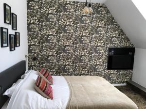 sypialnia z łóżkiem i czarno-białą ścianą w obiekcie B&B Fleurie w mieście Saint-Amand-Montrond