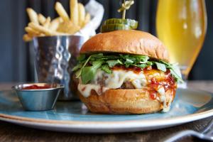 a cheeseburger on a plate with french fries at Kimpton Hotel Monaco Philadelphia, an IHG Hotel in Philadelphia