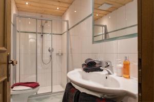 a bathroom with a shower and a sink and a toilet at Quality Hosts Arlberg - ALPtyrol Appartements in Sankt Anton am Arlberg +37 photos