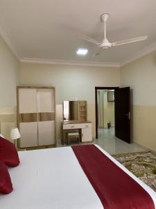 a bedroom with a large bed and a desk at Sama Sohar Hotel Apartments - سما صحار للشقق الفندقية in Sohar