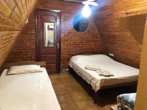 two beds in a room with a brick wall at Chalés Verde Vida in Conservatória