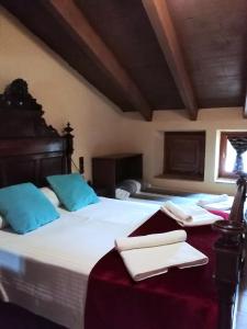 1 dormitorio con 2 camas y almohadas azules en Hostal Rural Mas Blanc, en Sant Martí de Centelles