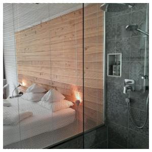 a bedroom with a bed and a glass wall at "Quality Hosts Arlberg" Hotel Lux Alpinae in Sankt Anton am Arlberg