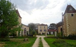 a dirt road in front of an old building at Le gîte de Gracio in Vic-Fezensac